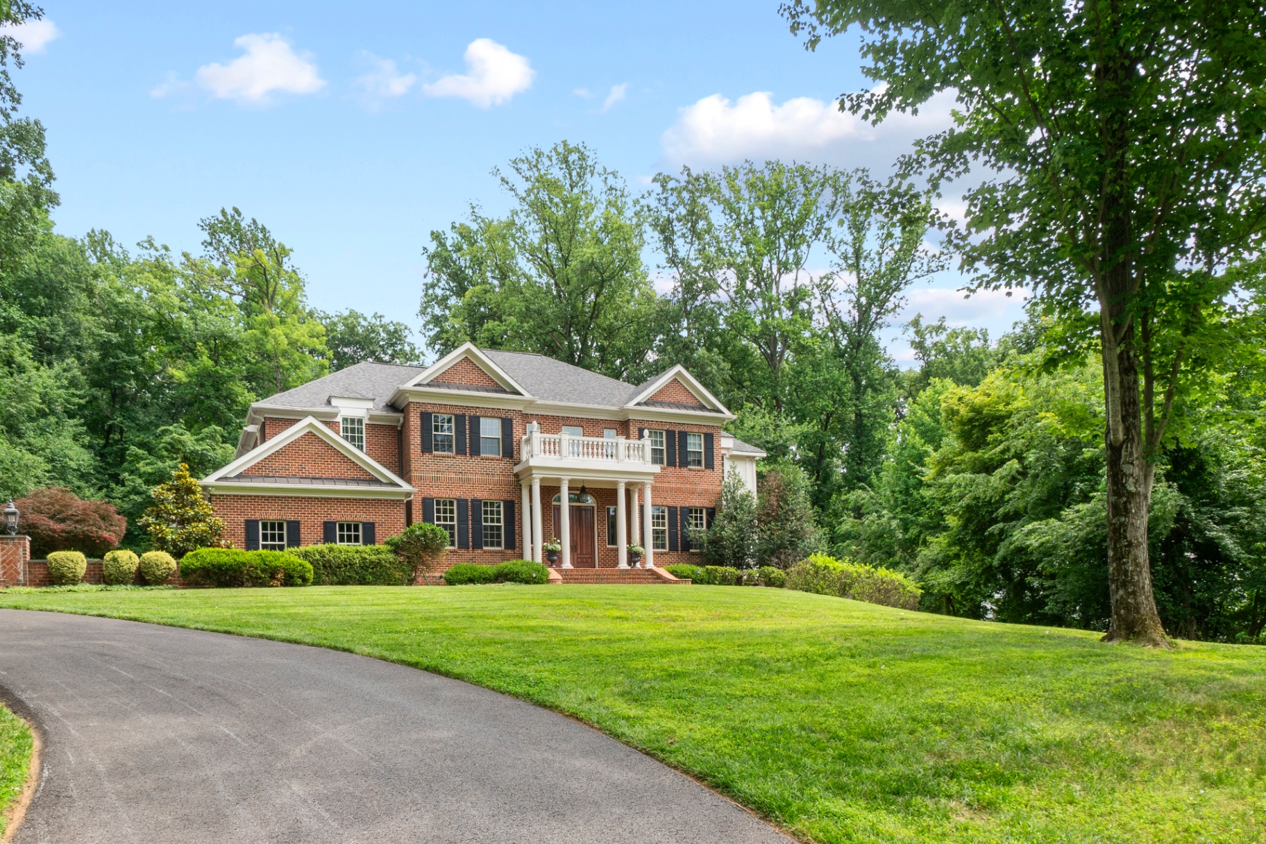 Classic Georgian brick home with white columns and green lawn